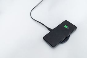 A smartphone charging wirelessly on a pad