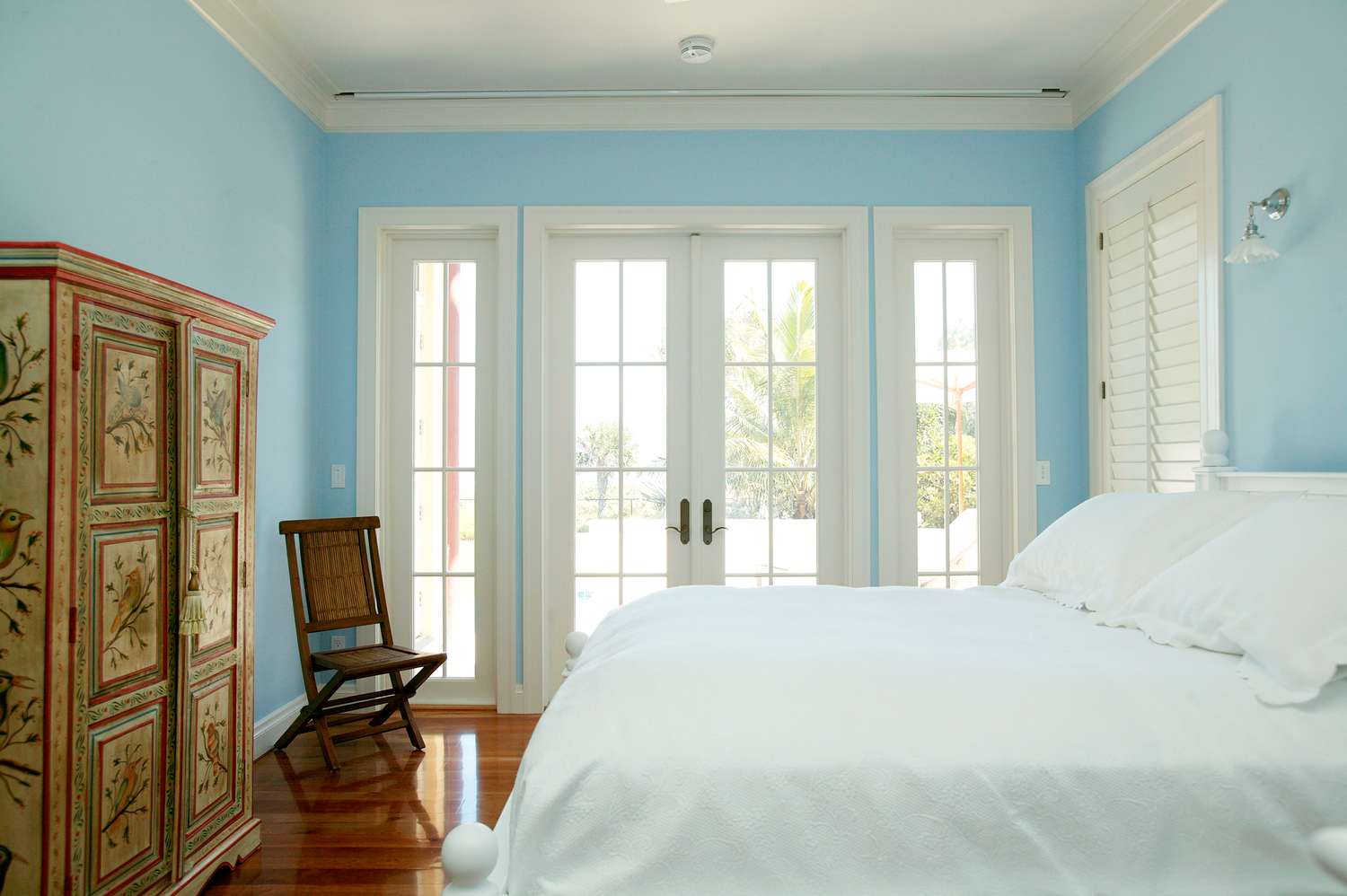 Minimalist bedroom with a bed large windows and a decorative cabinet