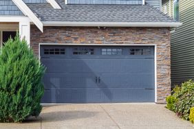 Residential house with a blue garage door and stone facade