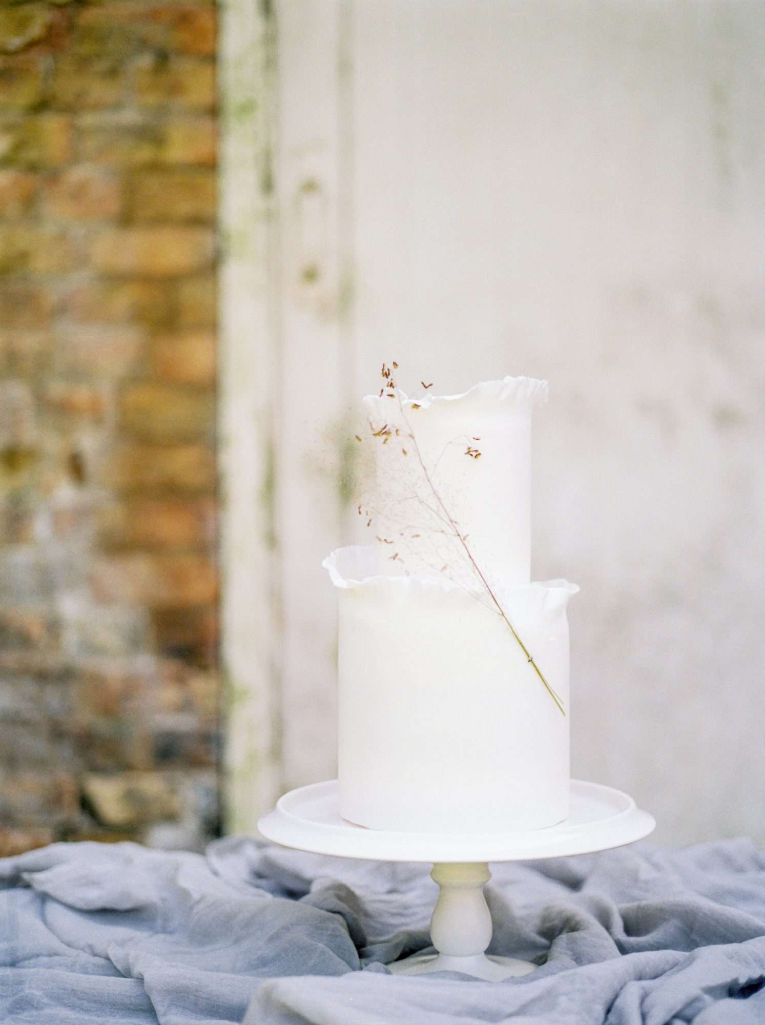 white wedding cake adorned with smokebrush sprig