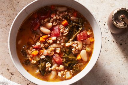 kale white bean and farro soup served in a white bowl