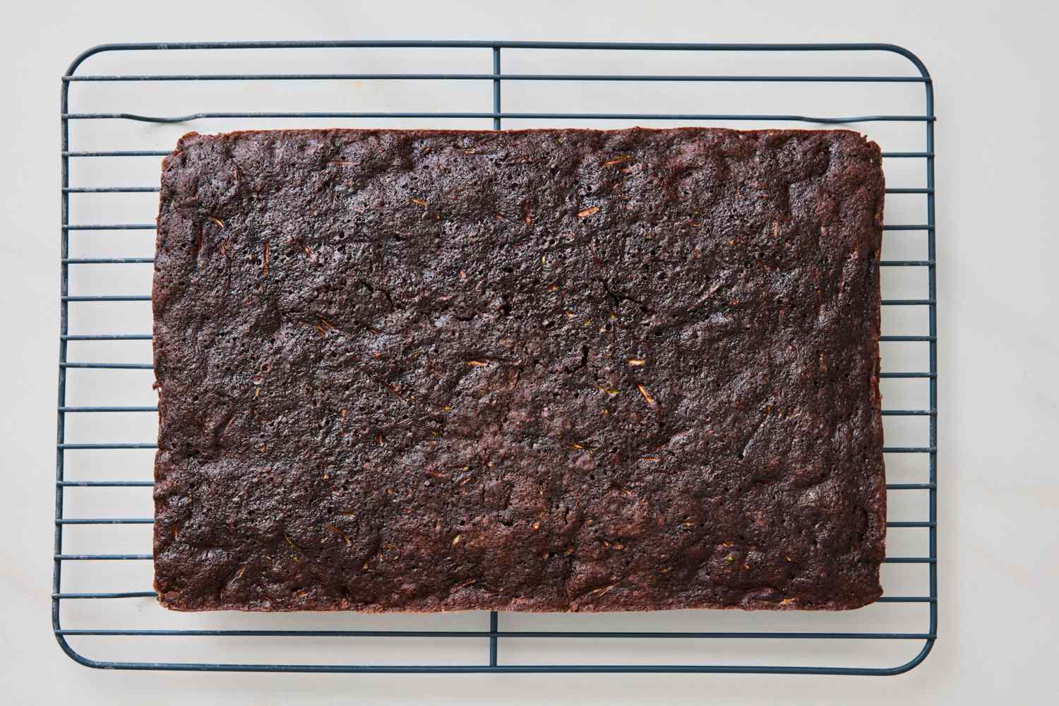 Chocolate sheet cake cooling on a wire rack