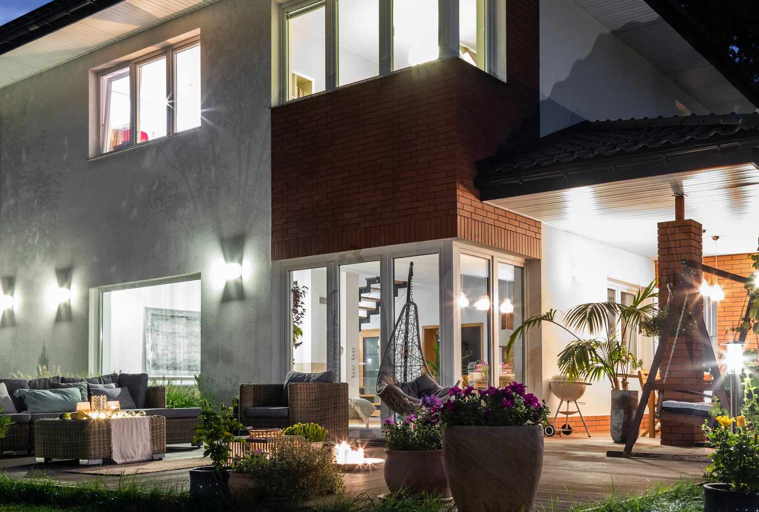 Modern house illuminated at night view of outdoor seating and large windows