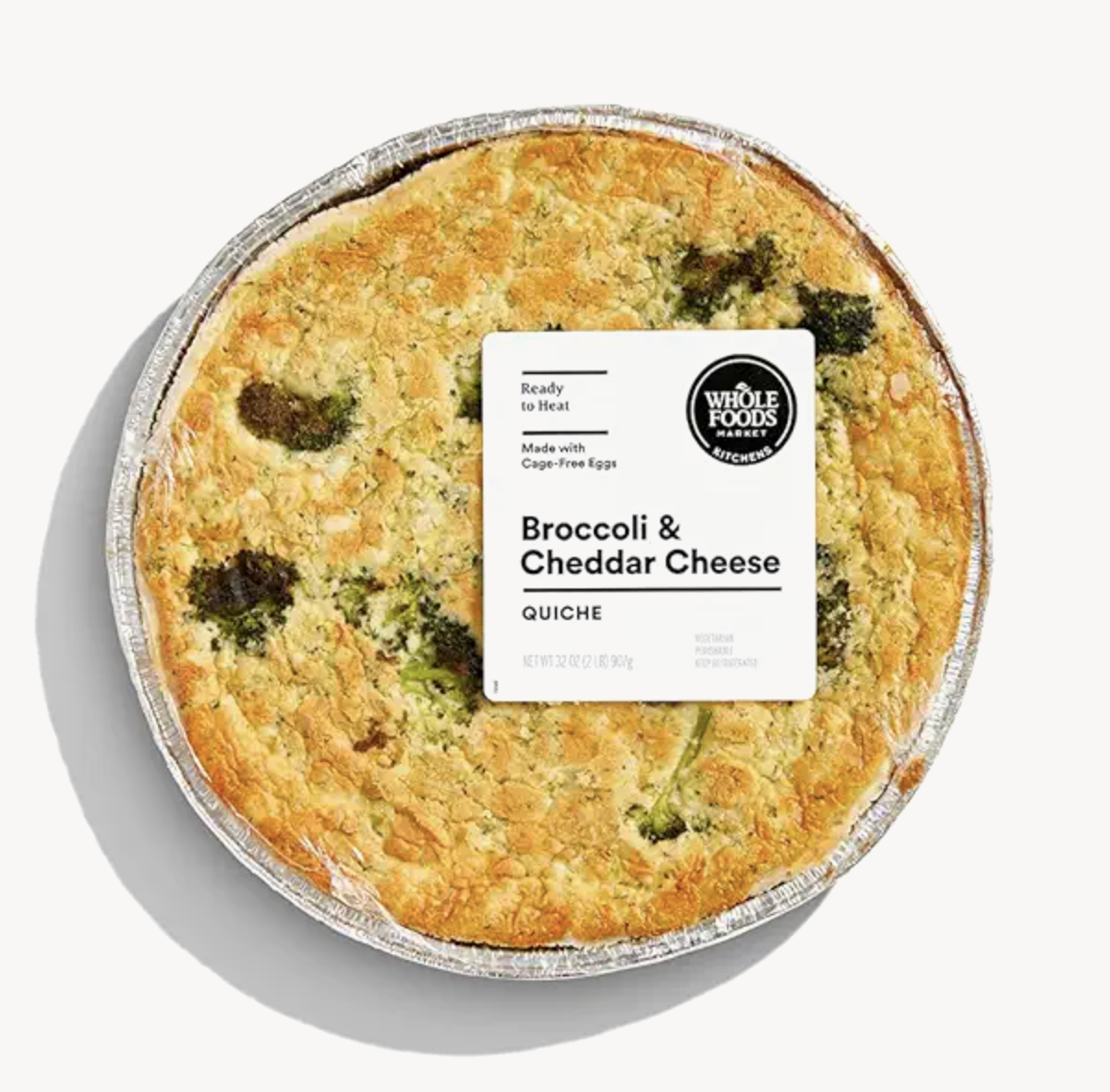 A broccoli and cheddar cheese quiche in a foil tray with a Whole Foods Market label