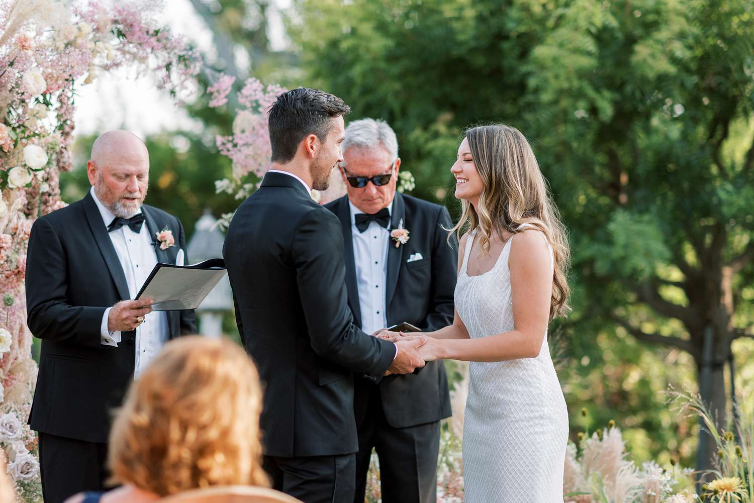 bride and groom exchanging vows during backyard wedding ceremony