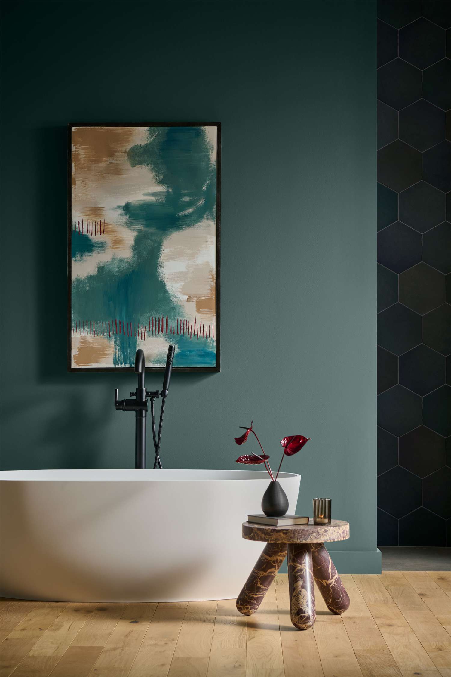 Modern bathroom interior with a white bathtub teal walls abstract art side table with decor and a honeycomb tile accent wall
