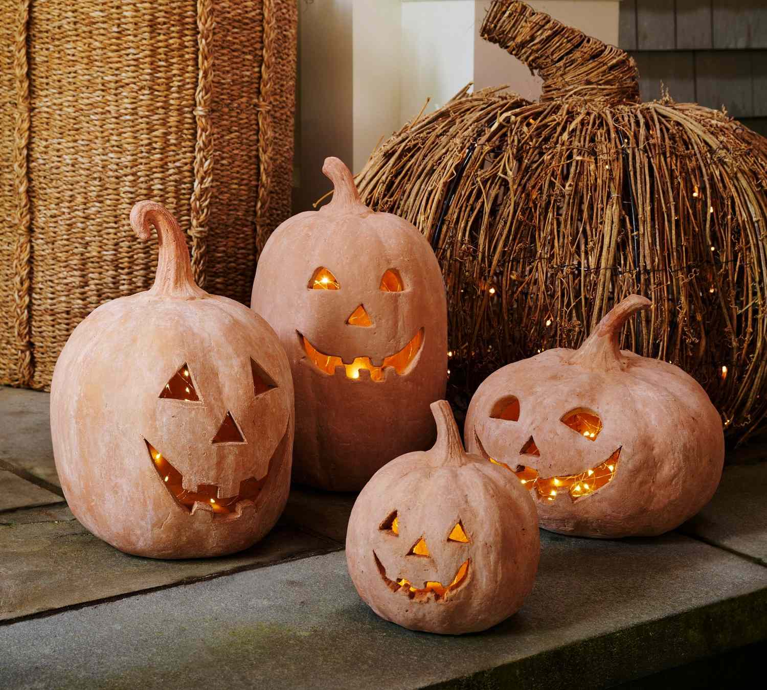 Terracotta jackolantern decorations on a patio displayed with a woven pumpkin for a festive arrangement