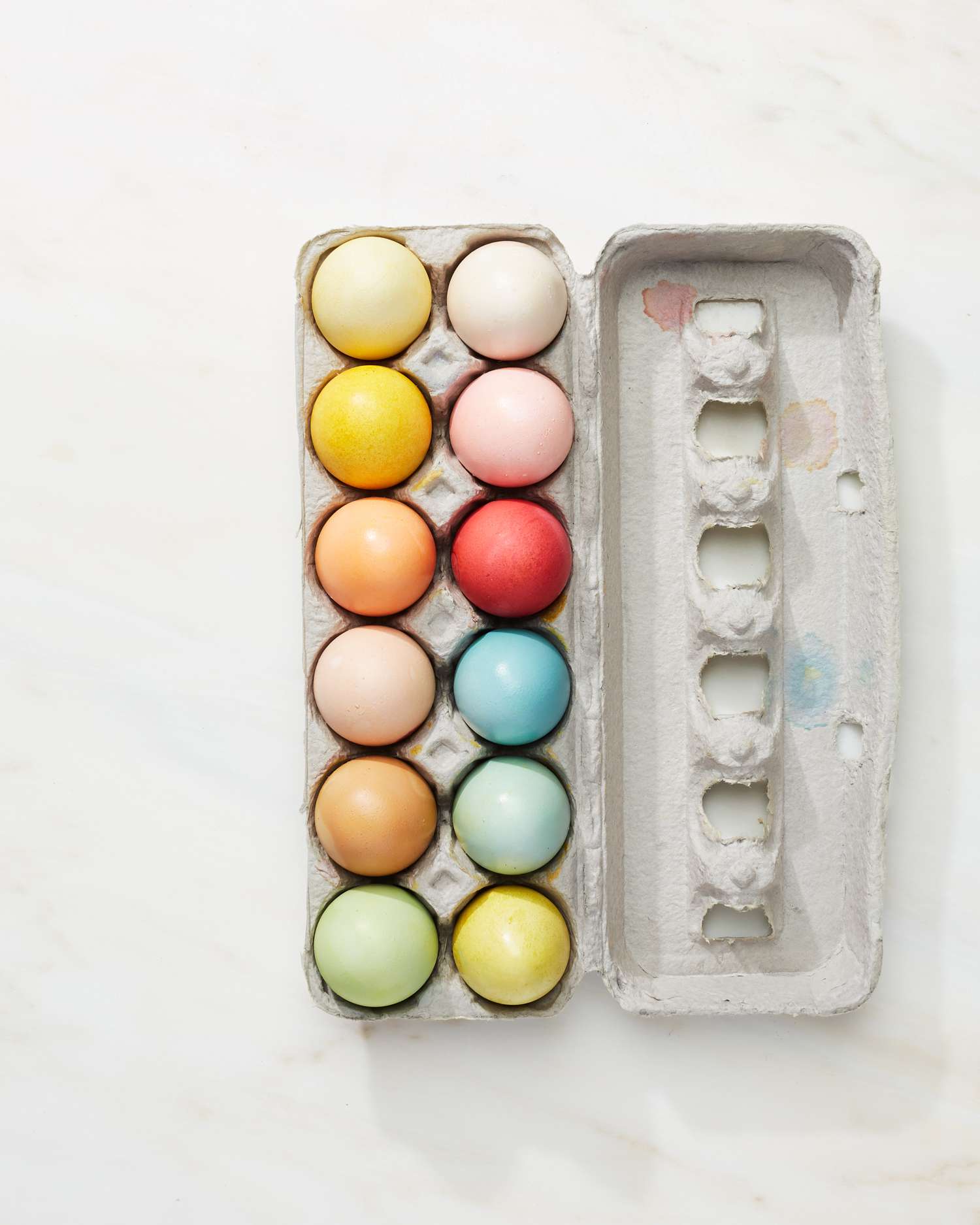 naturally dyed easter eggs in an egg carton