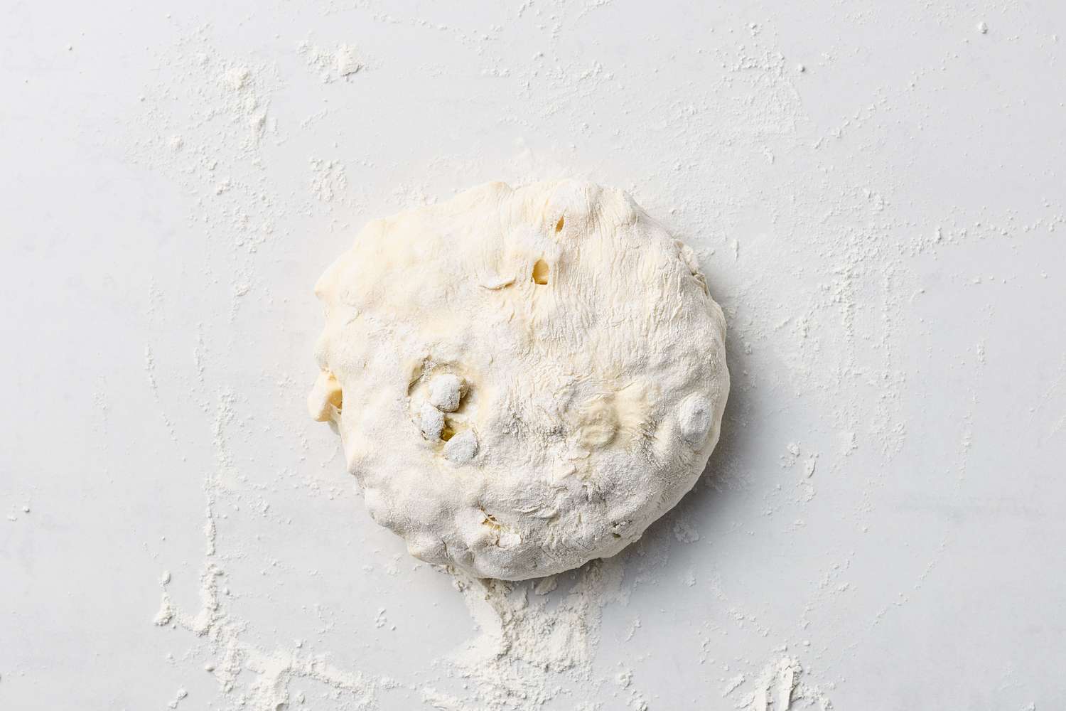 Unbaked dough for olive and cheese loaf on a floured surface