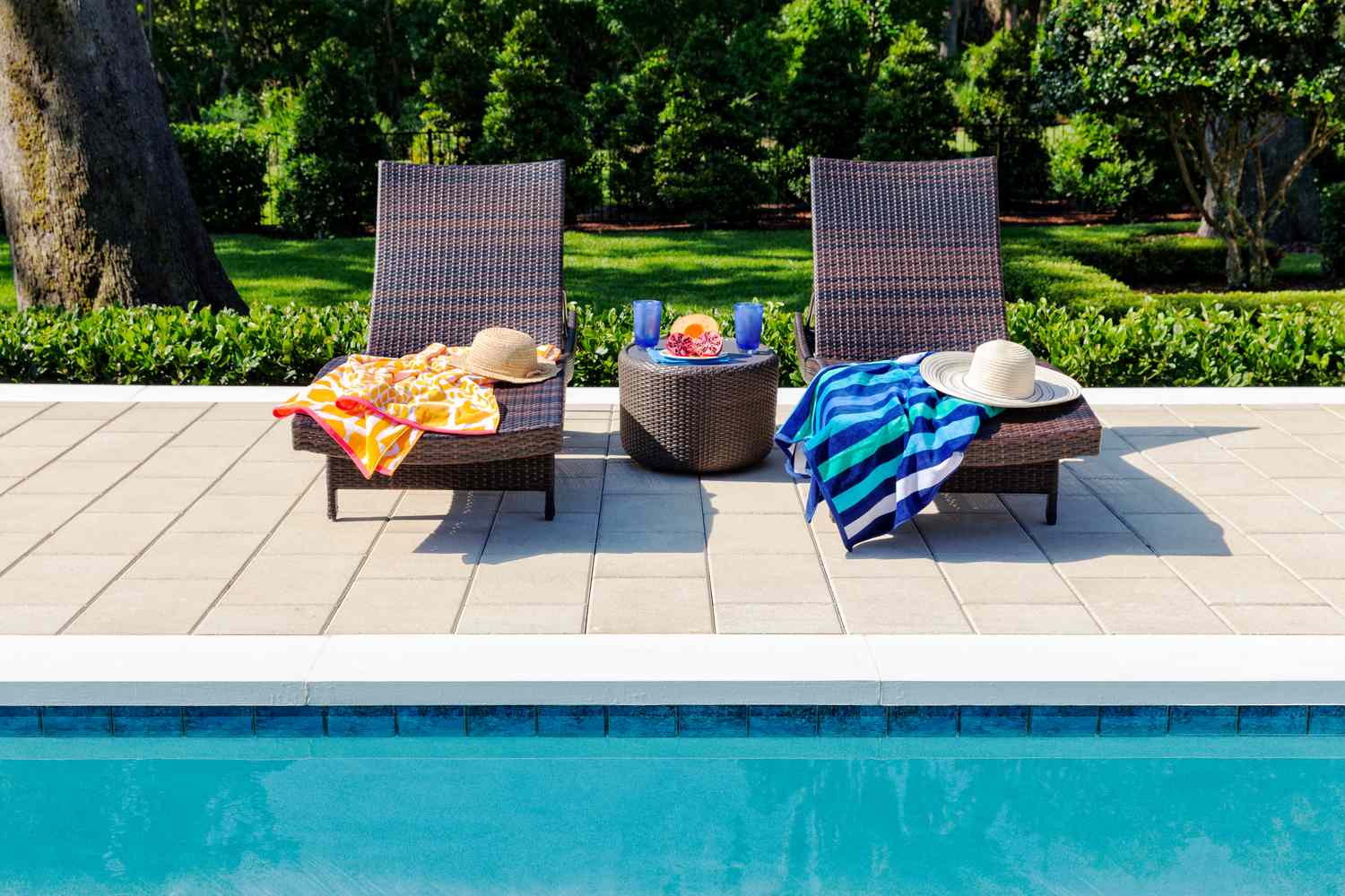 pool towels in chairs next to backyard pool