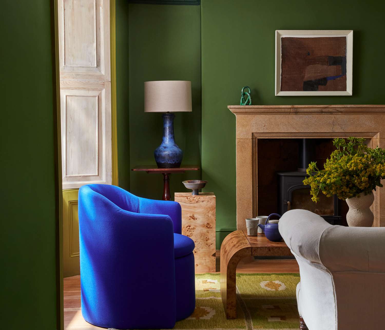 A green living room with a blue chair 