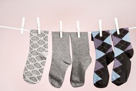 Four socks hanging on a clothesline using clothespins