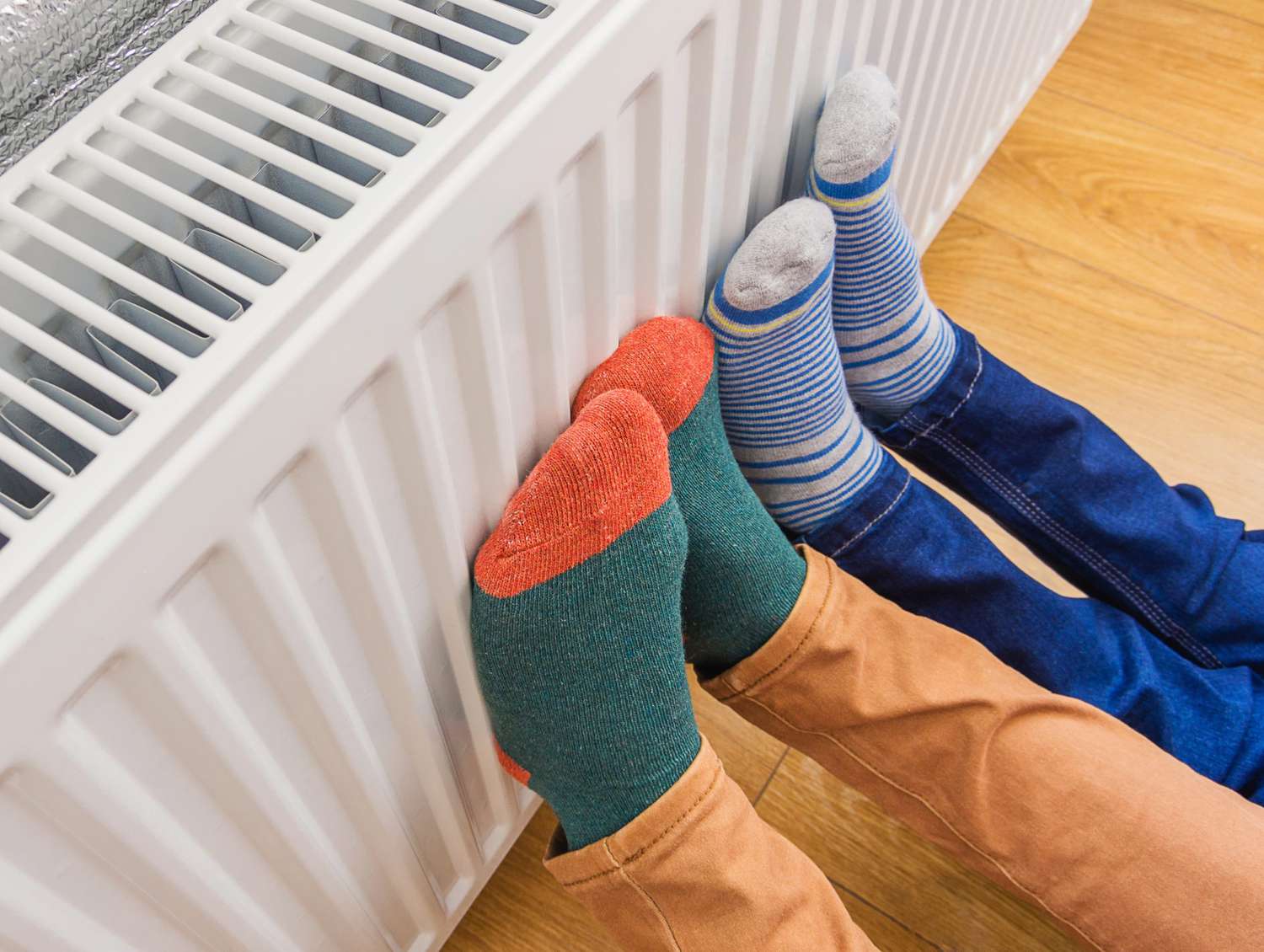 Parent and Child Wearing Socks, Keeping Feet Warm on Radiator