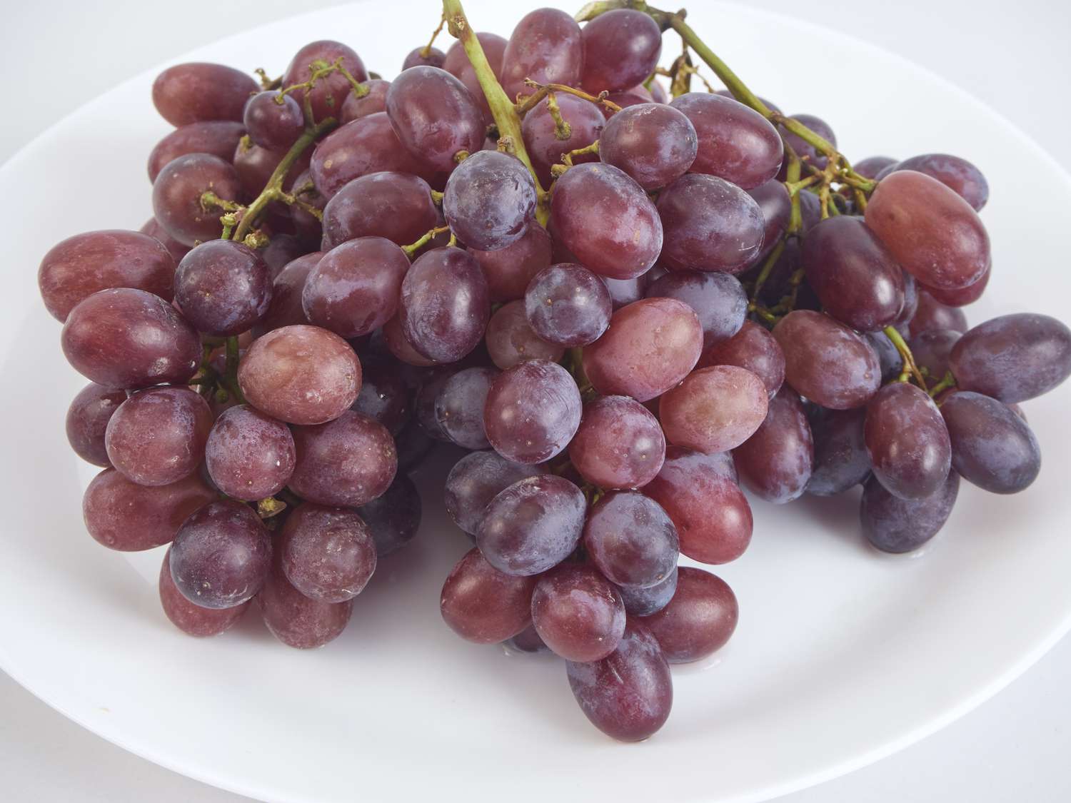 red grapes on white plate