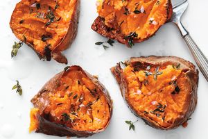 Baked sweet potatoes with thyme and sea salt on a light background
