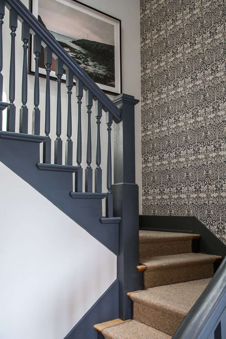 painted staircase in benjamin moores deep space and patterned wallpaper accent wall