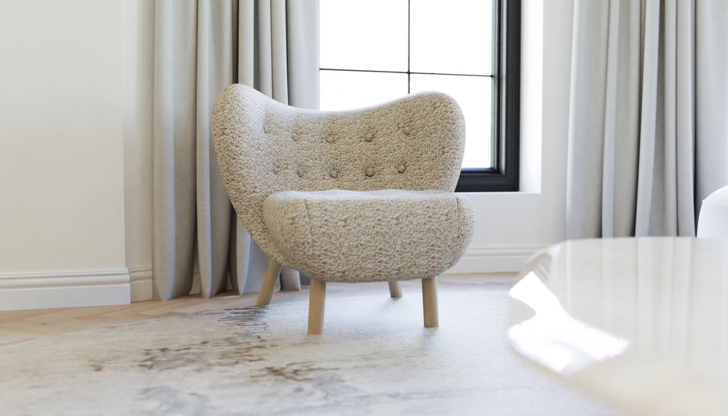 A plush textured armchair in a room with a window and lightcolored curtains