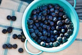 overhead view of washed blueberries in a teal colander 
