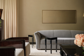 A modern living room setup with a sofa armchairs and a vase of flowers