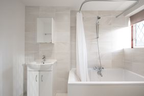 Modern bathroom with a bathtub shower sink and a light tile design