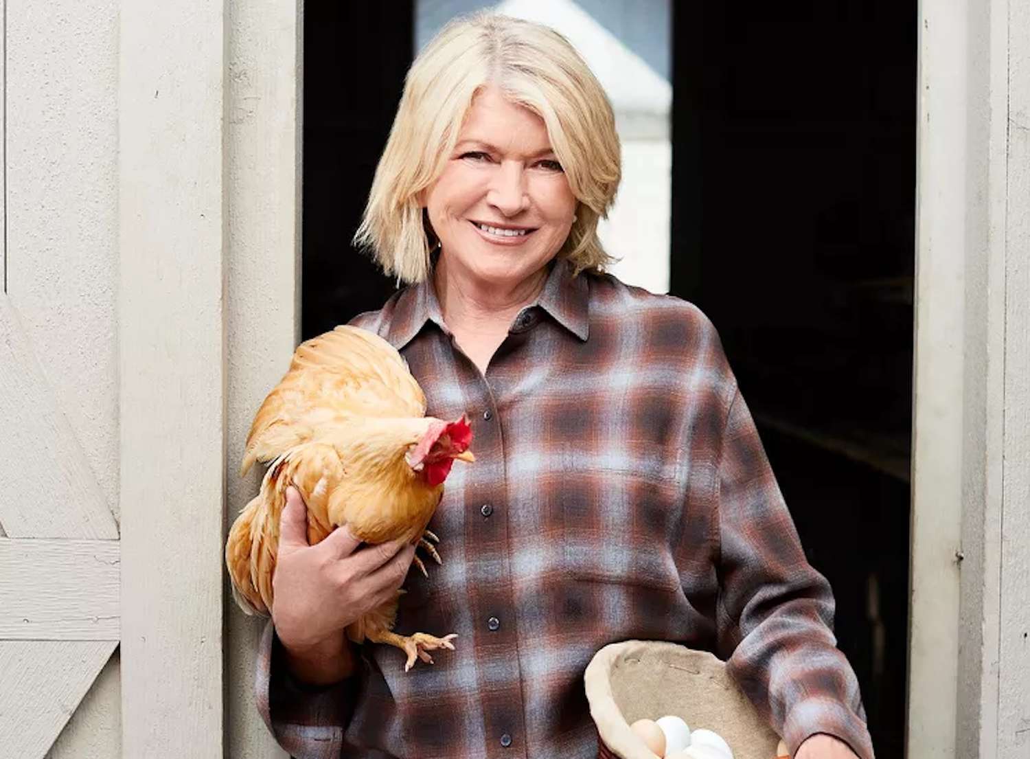 decorvow holding a chicken and a bowl of eggs by a door