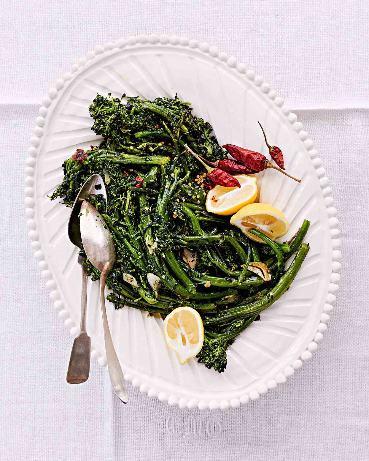 sprouting broccoli with peperoncini served with lemon wedges