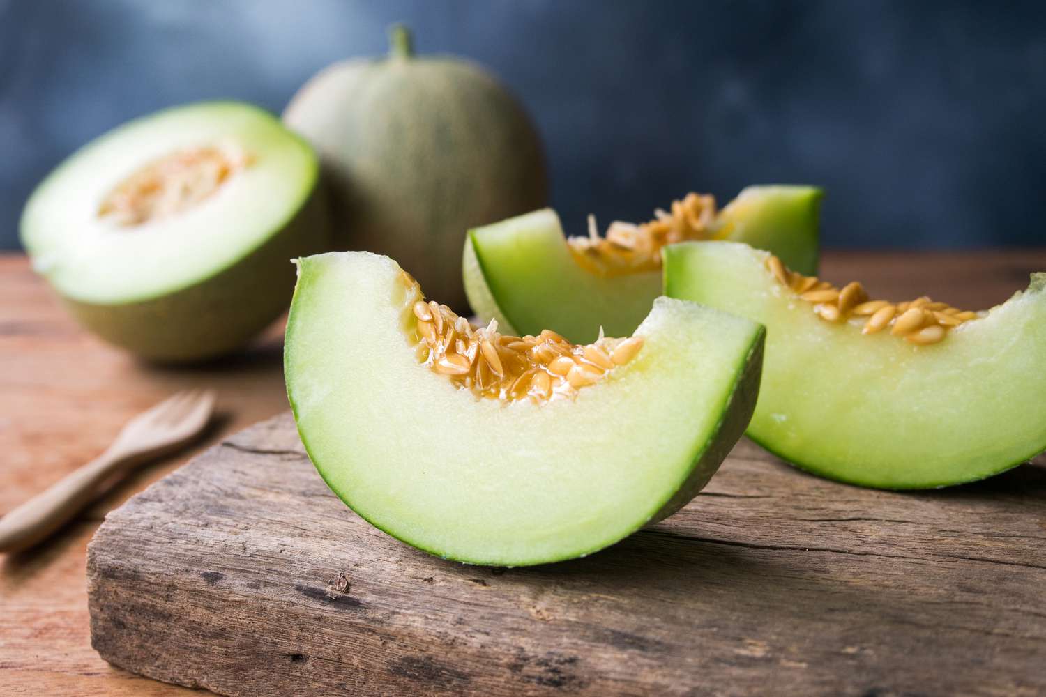 honeydew melon slices on wooden board