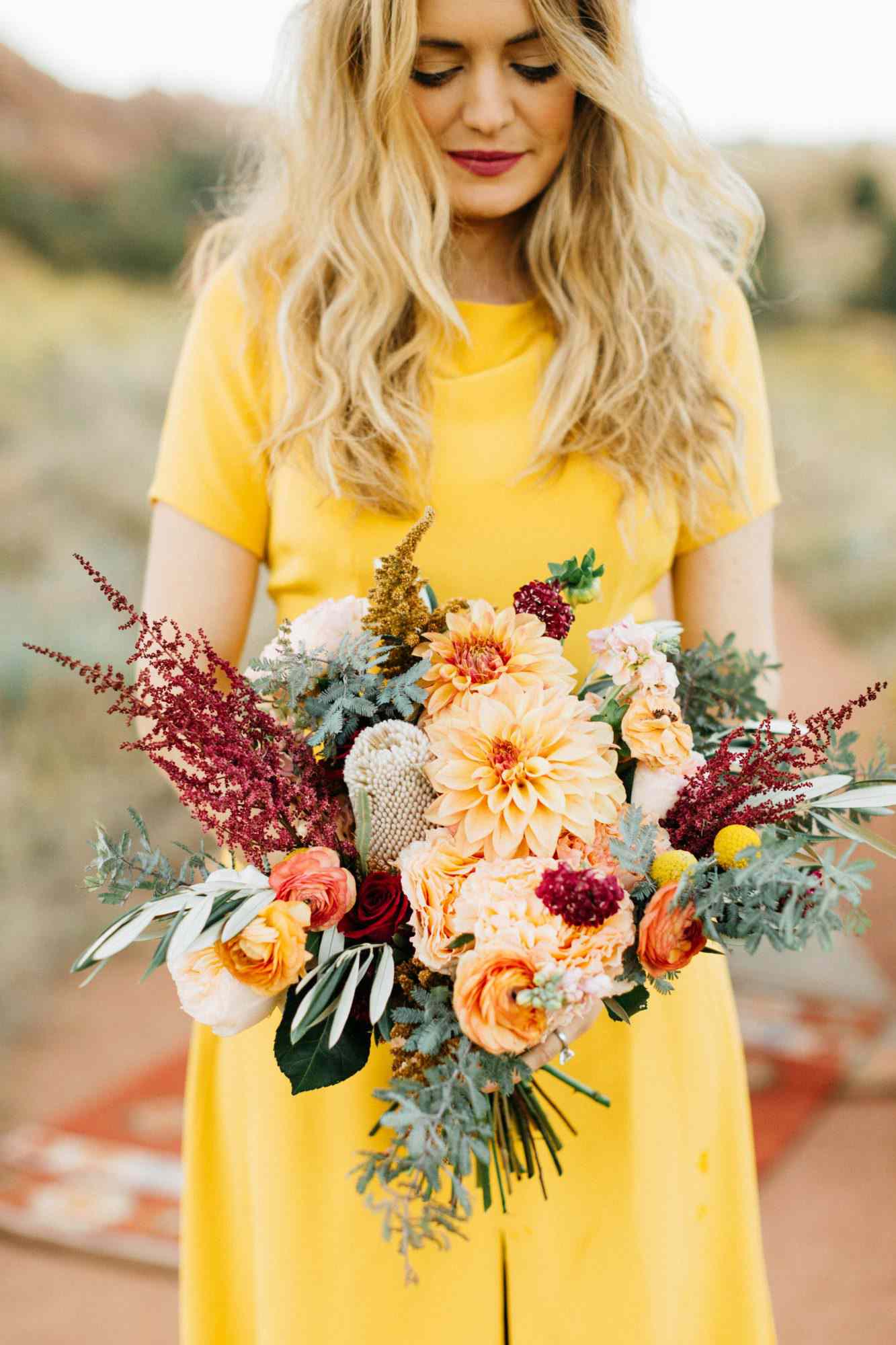 bride yellow dress dahlia bouquet orange flowers red green