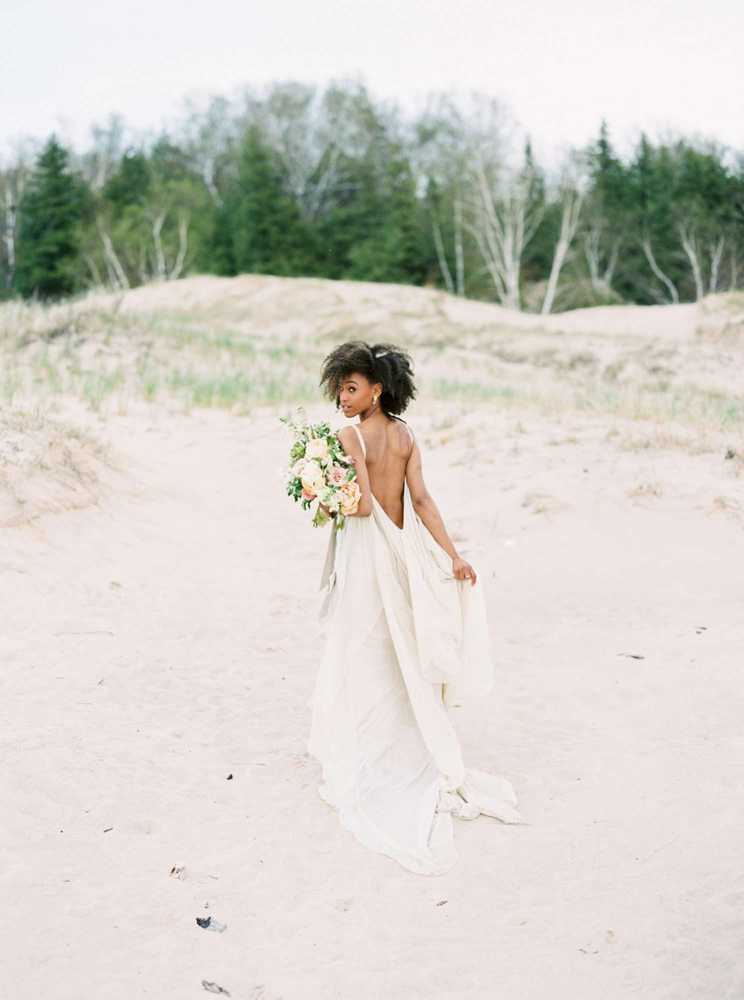 bride wearing backless wedding dress on the beach