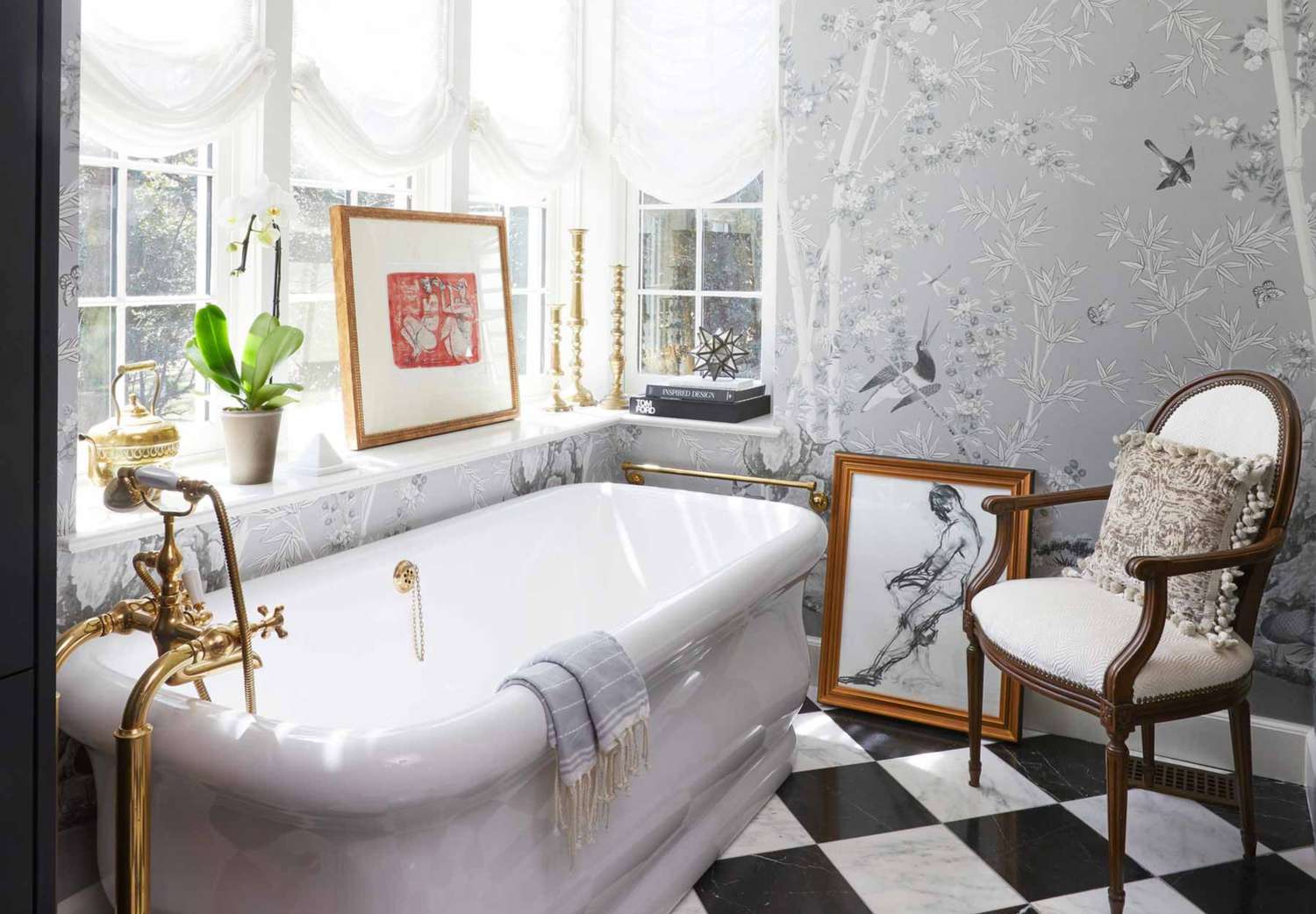 Luxurious bathroom featuring a freestanding bathtub, elegant decor, and framed artwork