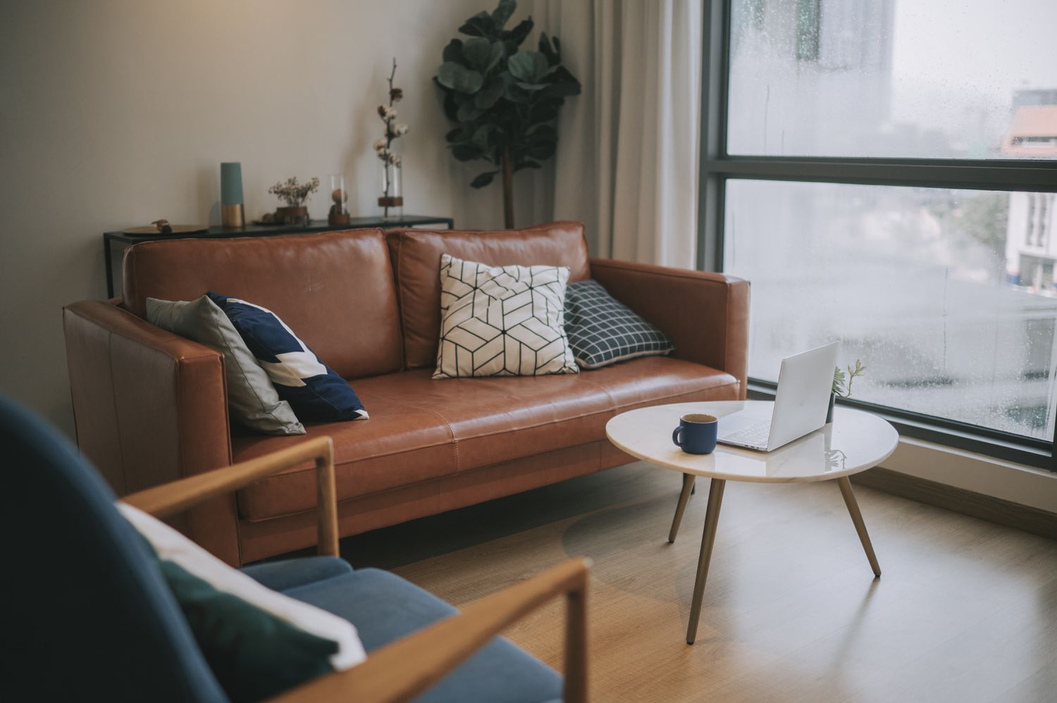 An interior of the residential building living room during day with coffee table, cushion on sofa