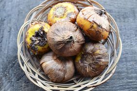 A basket filled with bulbs resting on a textured surface