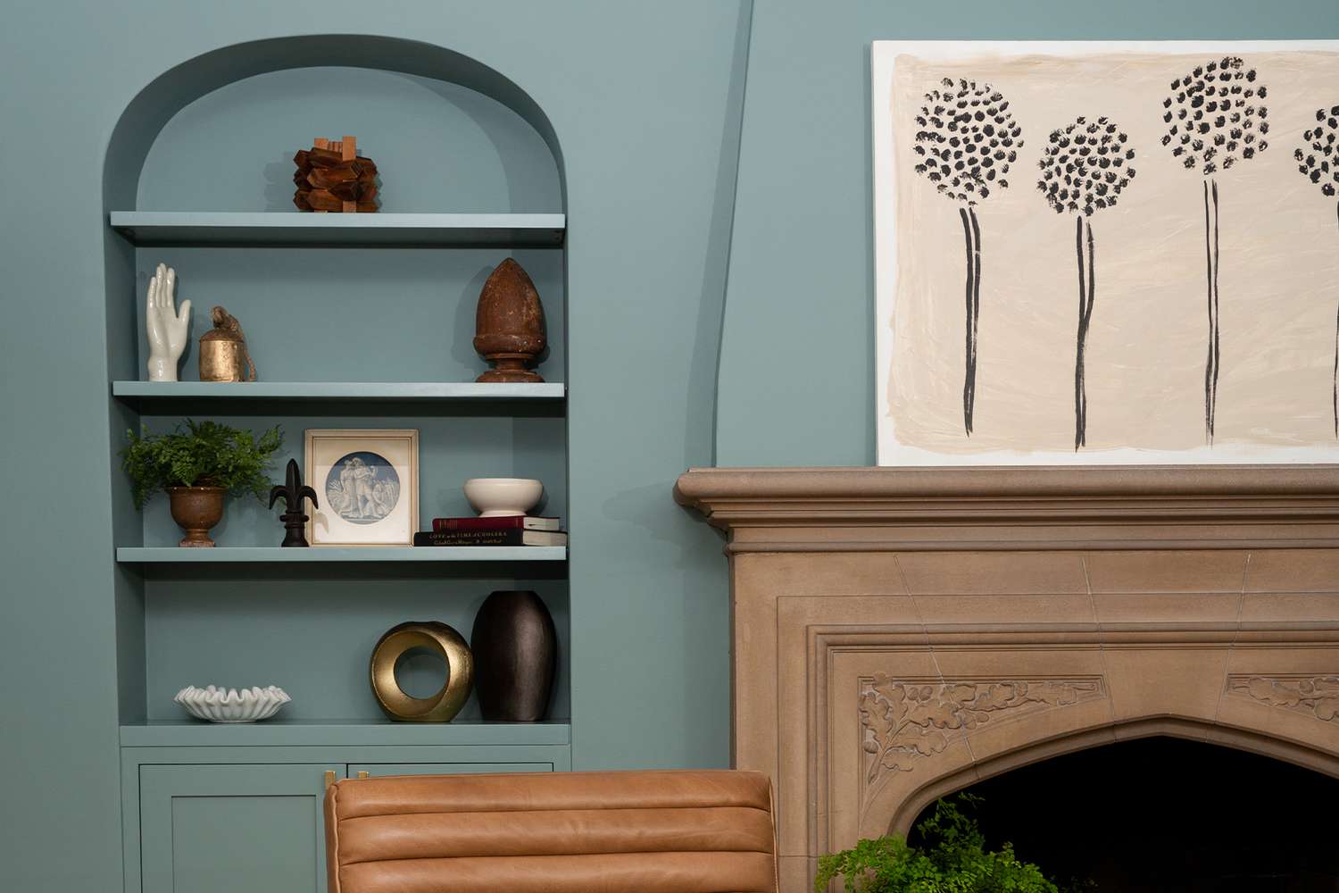 teal round wall shelfing inset with fireplace and artwork