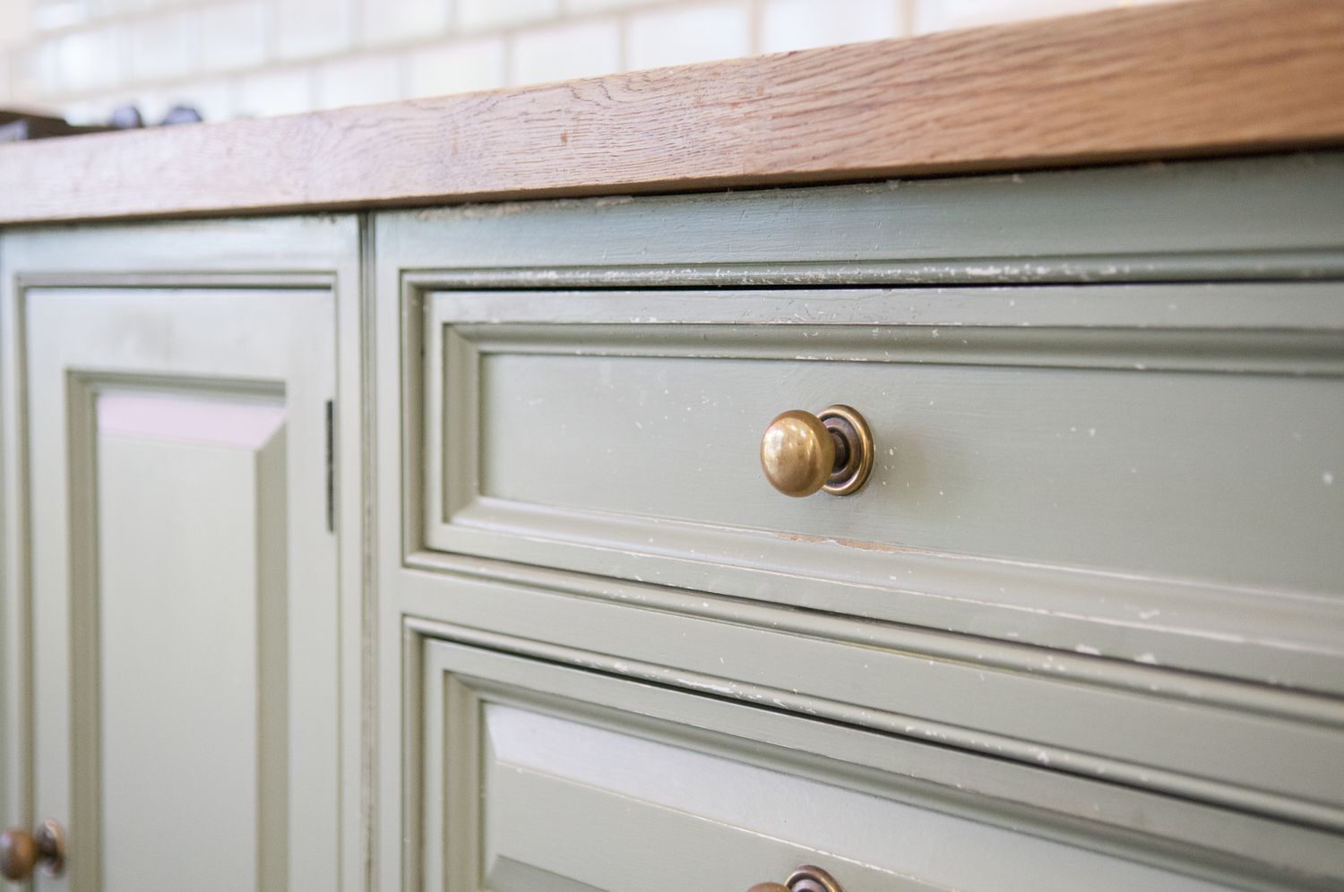 Closeup of wooden cabinets with brass knobs and a countertop