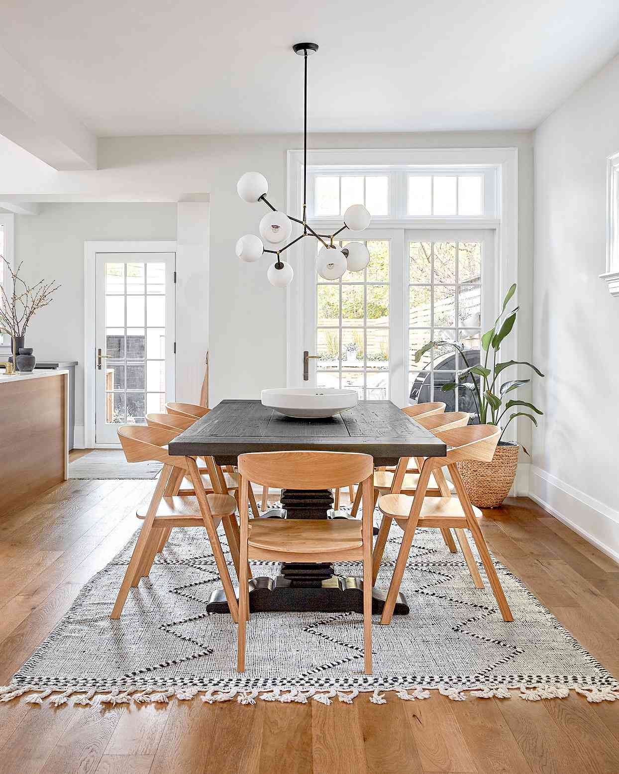Dining area with large woven rug and wooden table and chairs