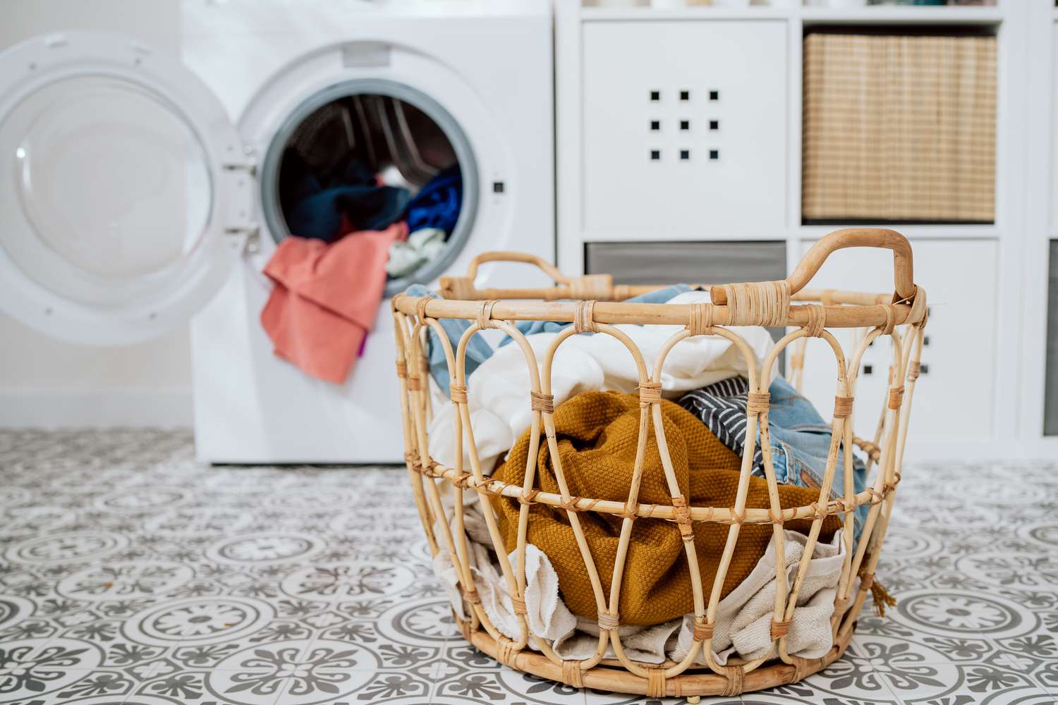 Clothes in laundry basket sitting in laundry room near dryer