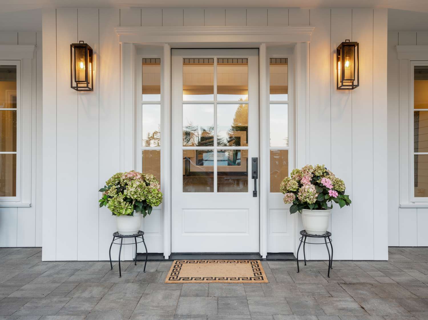 white front porch with flowers in pots 