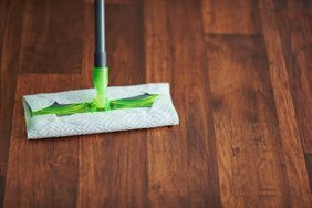 Household time. Closeup on mop and floor in the modern living room