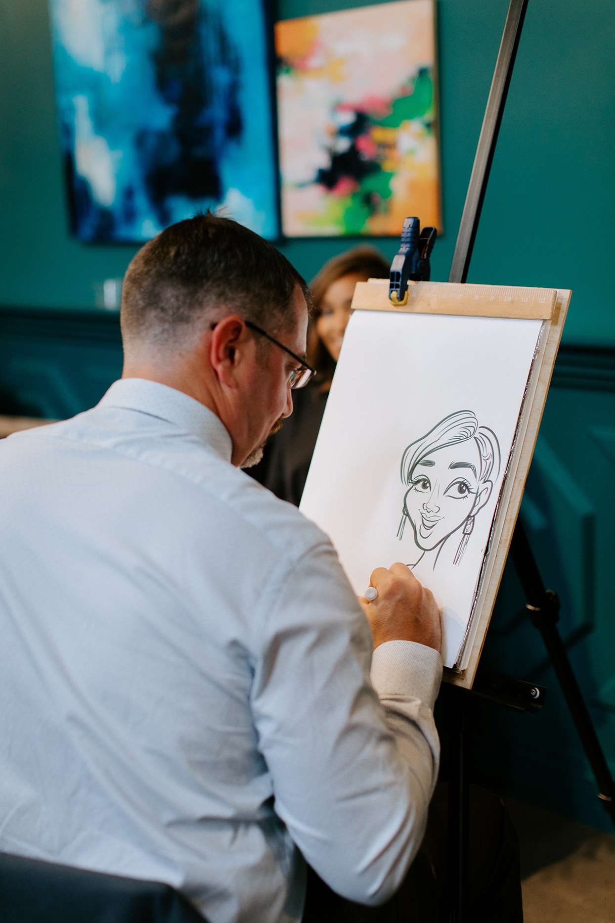 man drawing cartoons at wedding reception