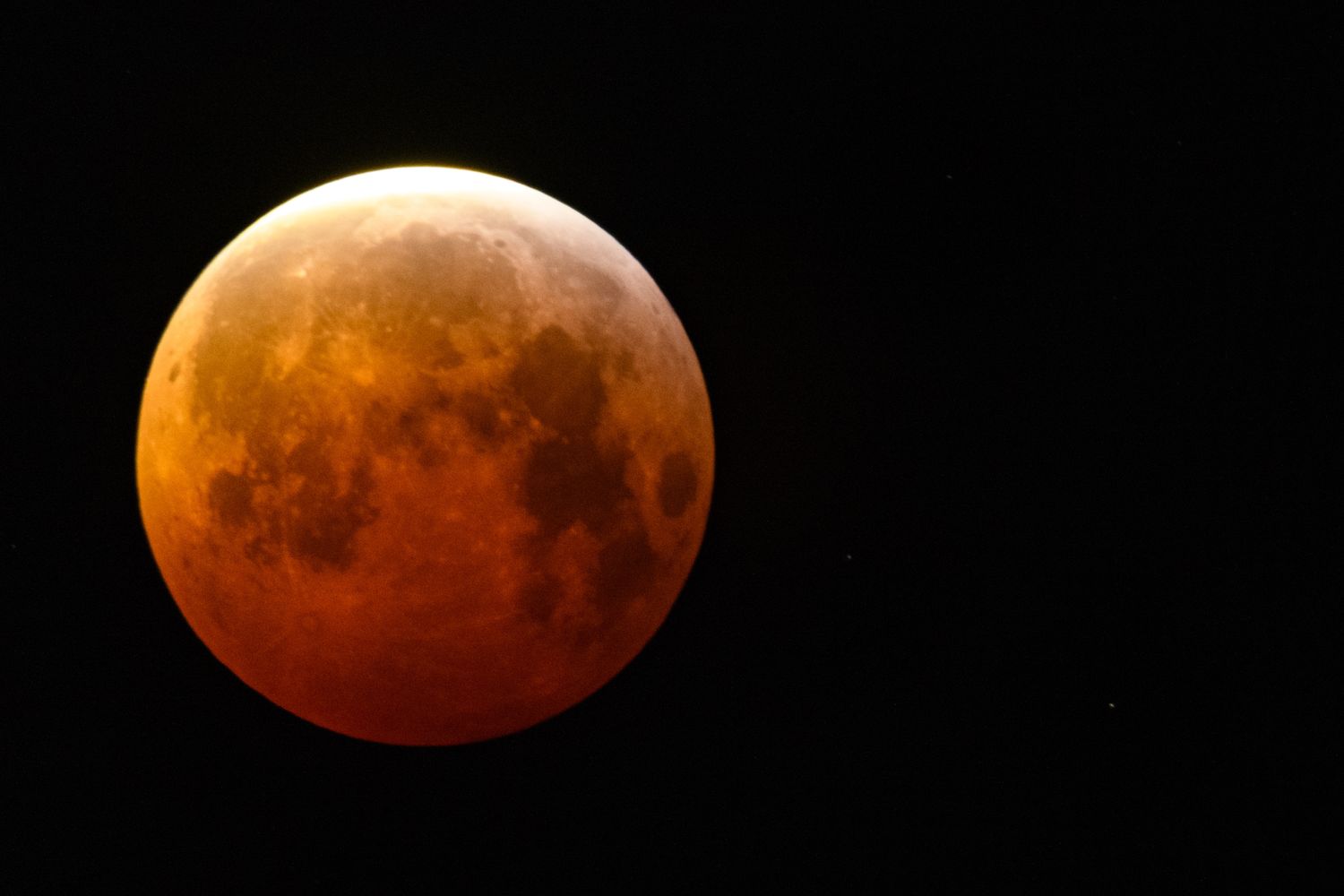 Full moon during a lunar eclipse showing reddish tint and detailed surface features