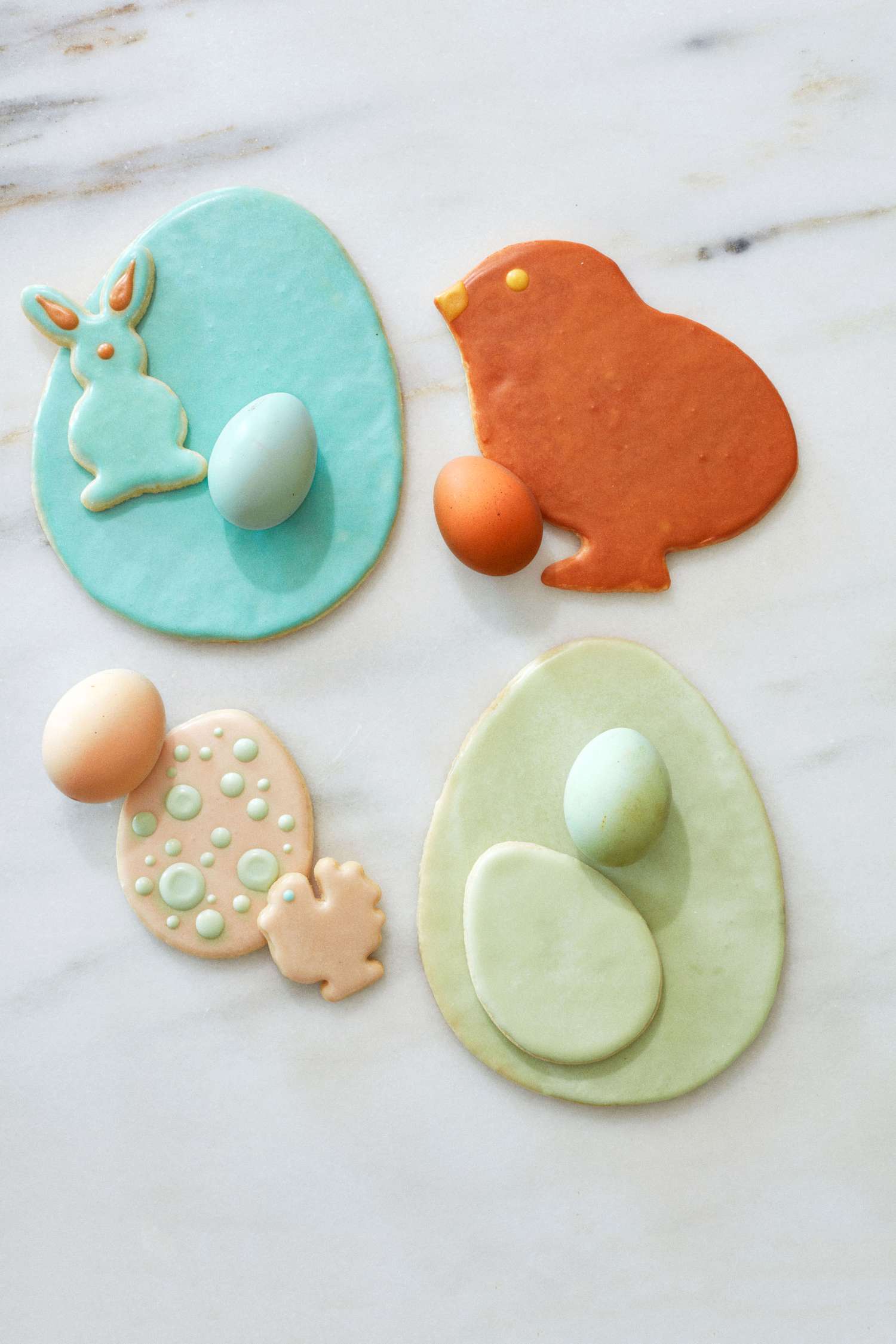 frosted chickens and easter egg sugar cookies on marble countertop