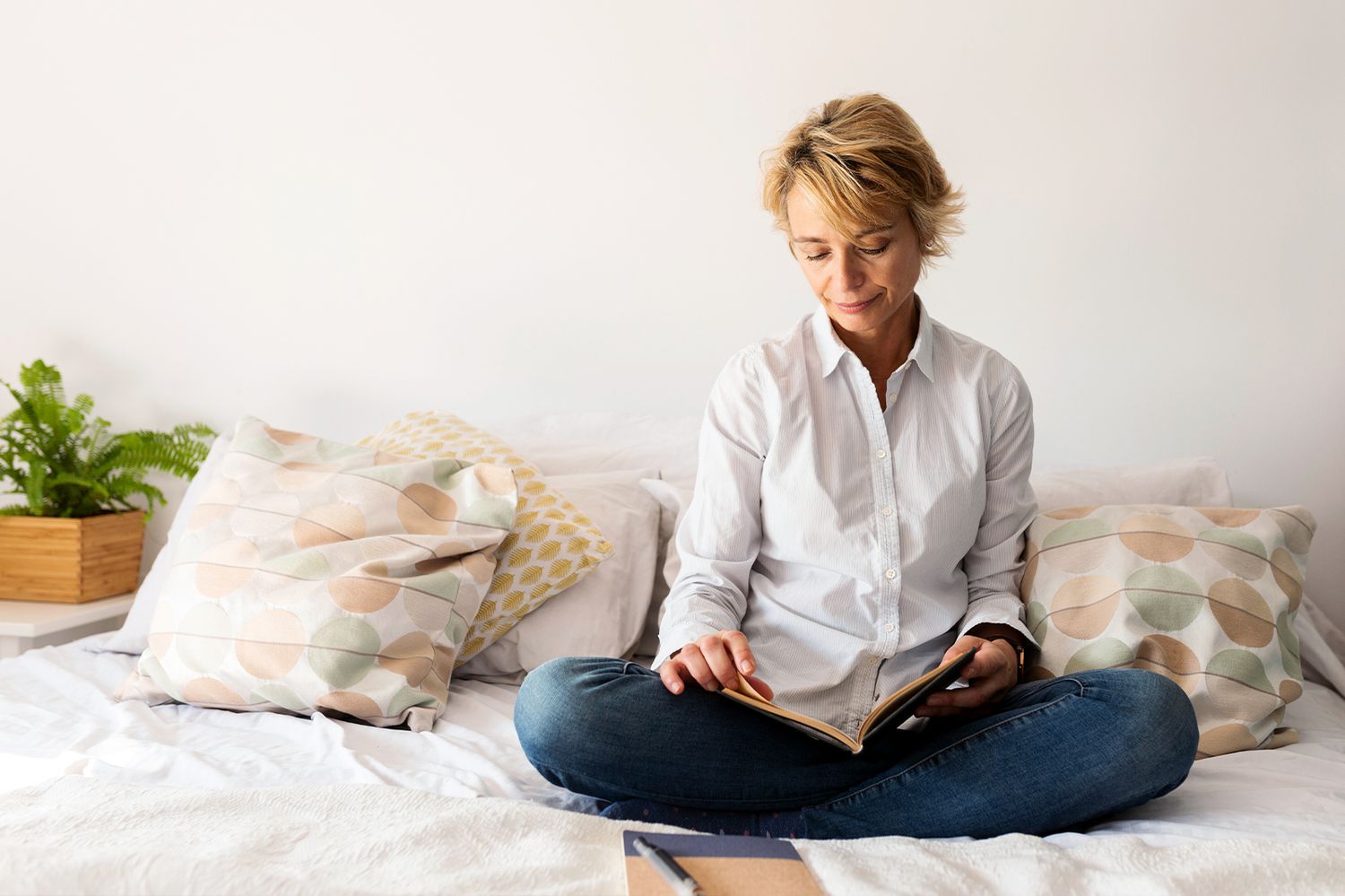 woman reading on bed in outside clothes