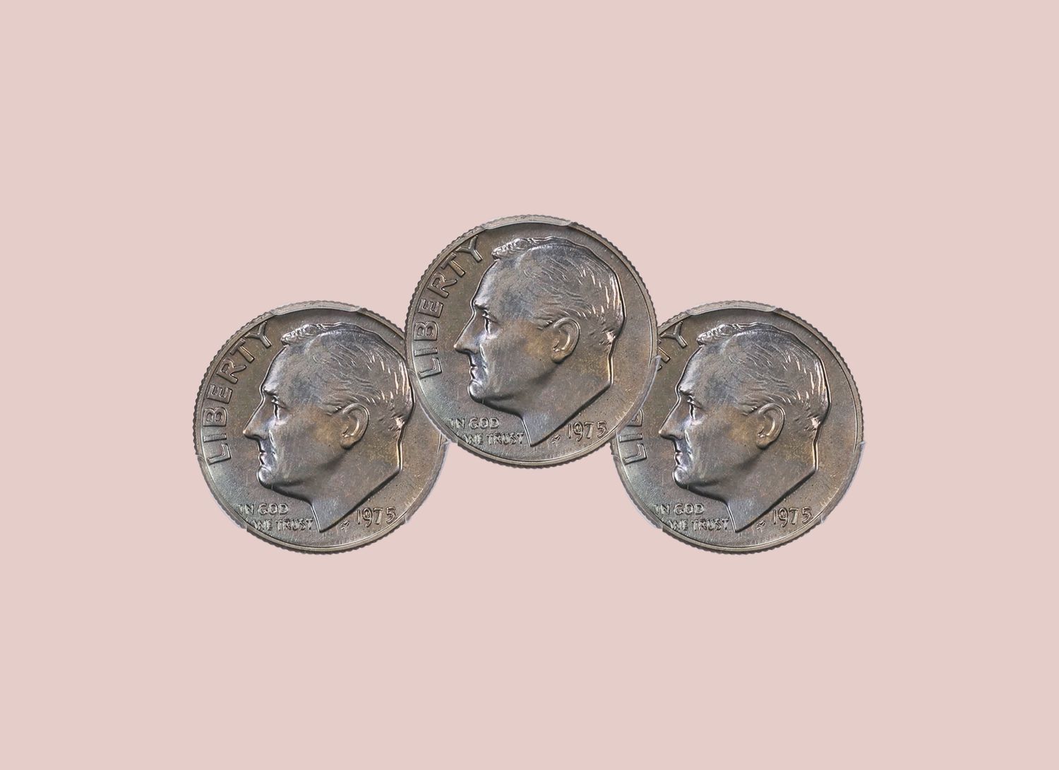 three 1975 dimes on a pale pink background
