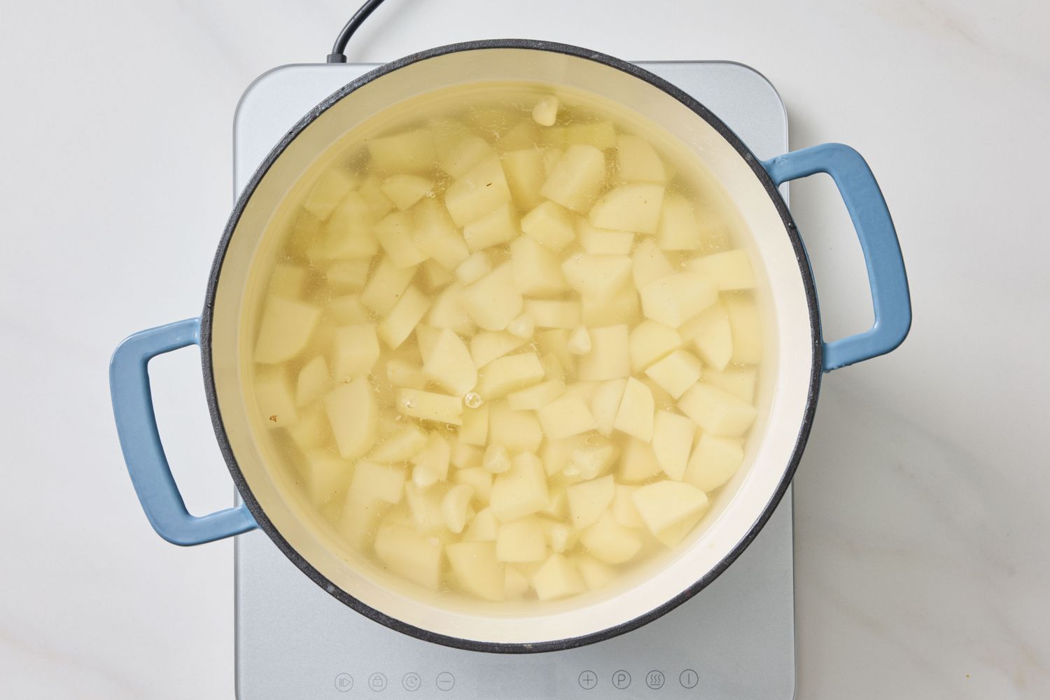 Diced potatoes being boiled in a saucepan