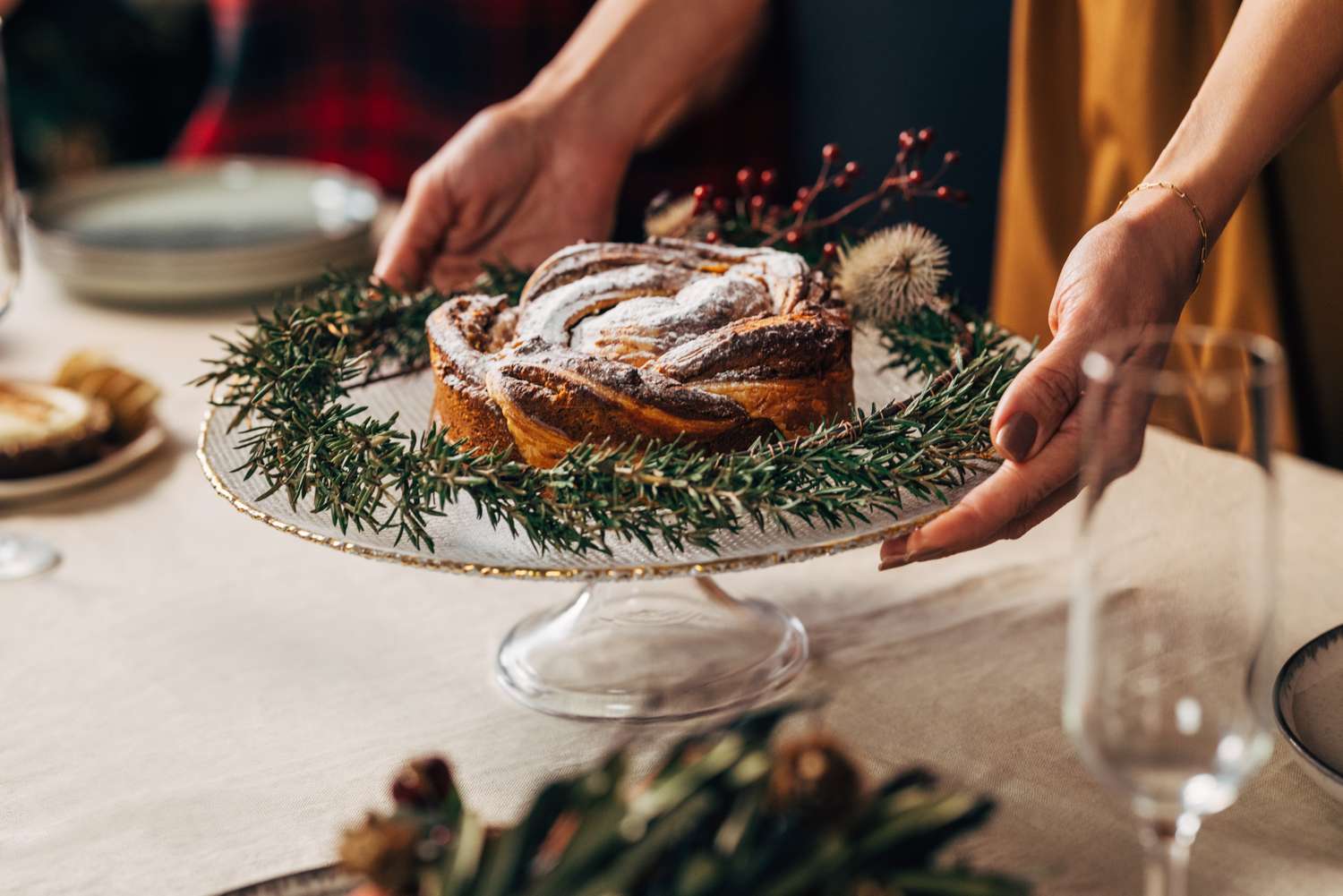 A cropped photo of an unrecognizable Caucasian female serving Christmas cake on Christmas Eve. (from above view)