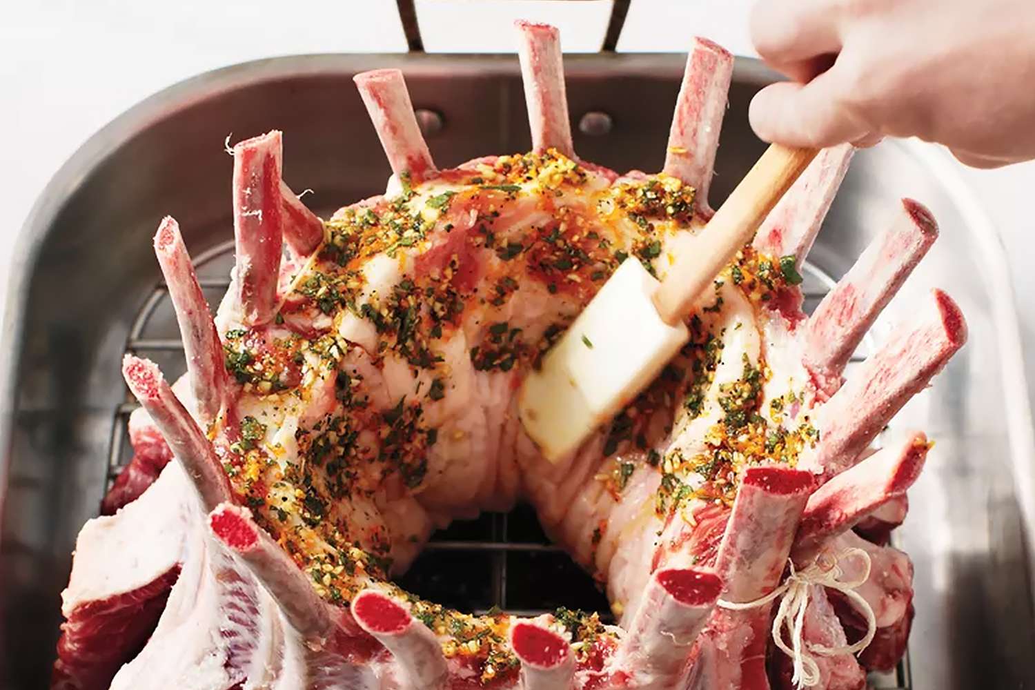 overhead view of someone adding rub to a pork roast