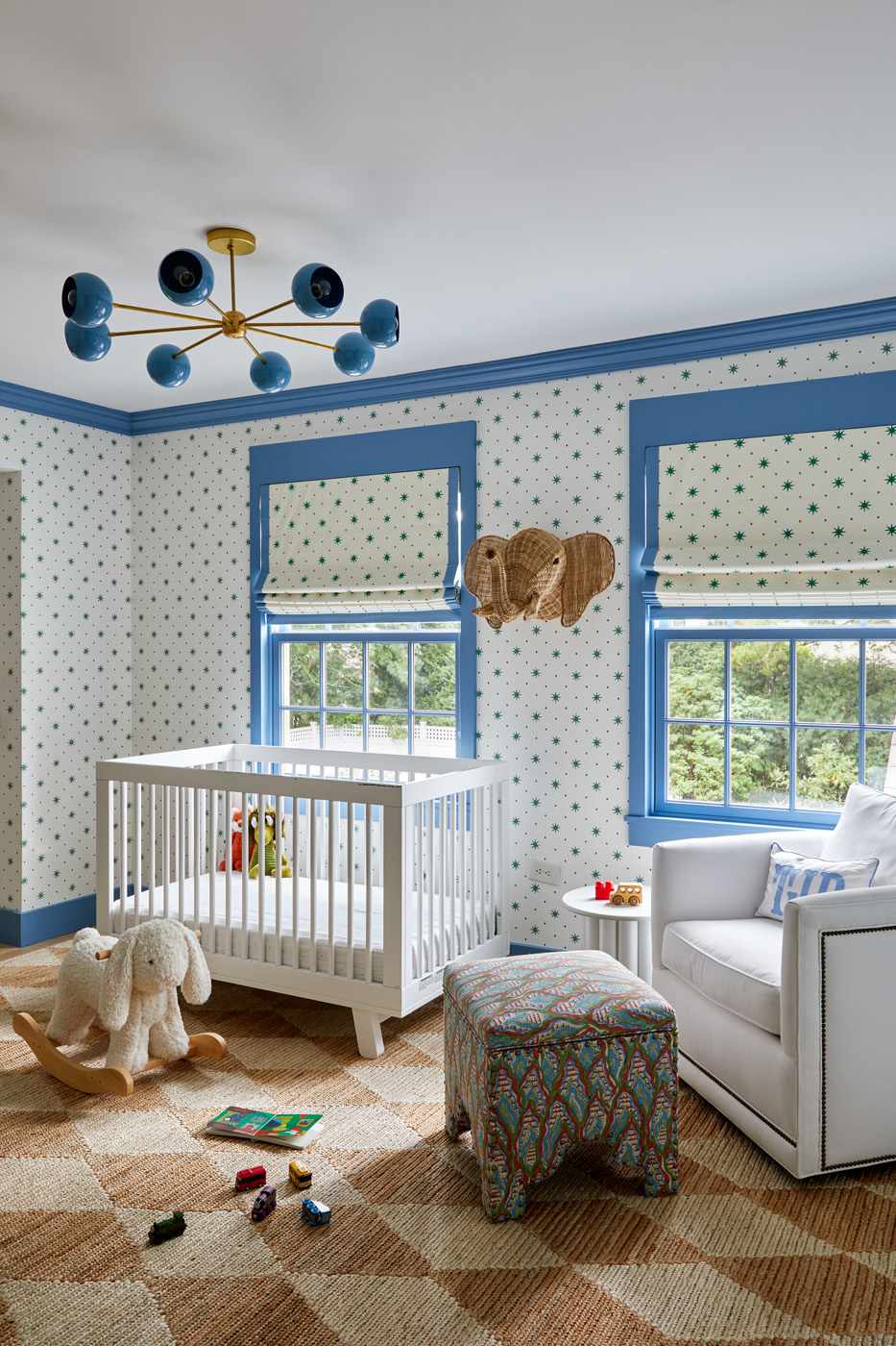 kid's room with blue print wallpaper and white furniture