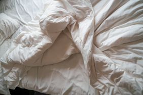 Unmade bed featuring crumpled sheets and pillow