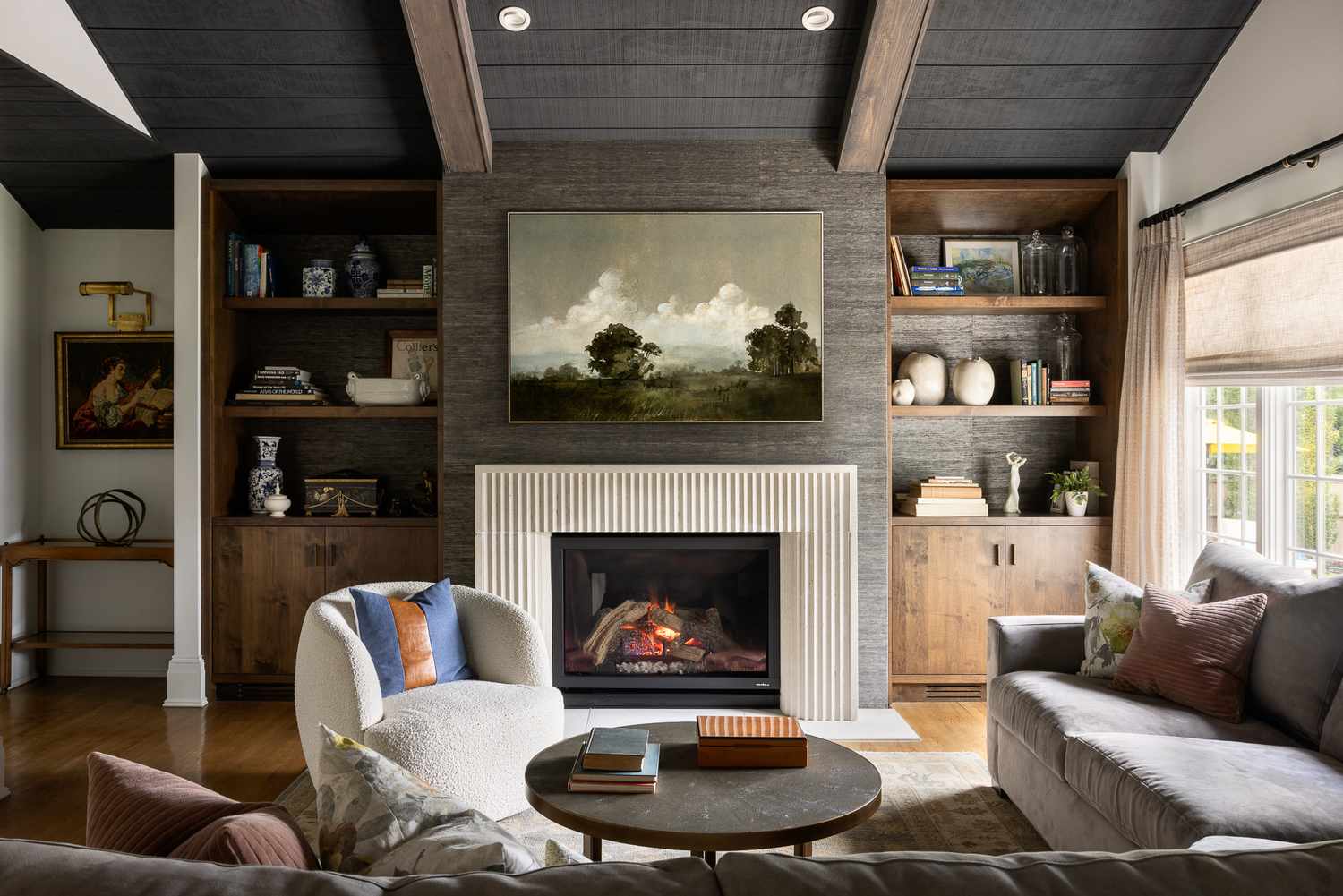 A living room with a fireplace bookshelves and seating area