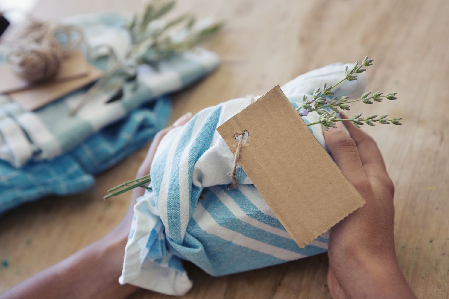Young woman holding a gift wrapped in reusable fabric